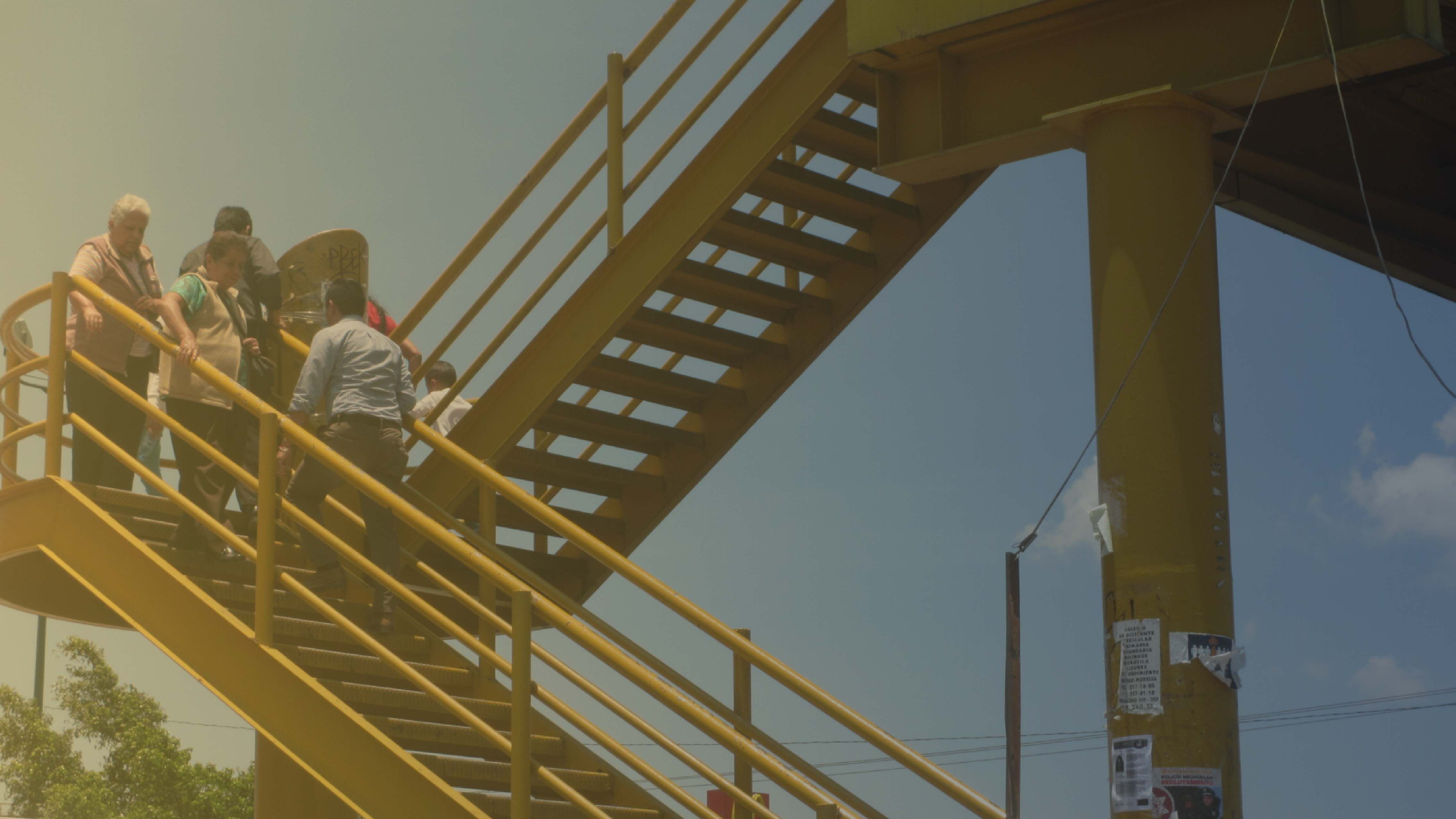 Imagen de personas mayores bajando un puente peatonal